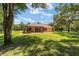 Home exterior showcasing a large backyard and screened patio at 10020 Sw 202Nd Cir, Dunnellon, FL 34431