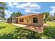 House exterior showcasing a screened patio, landscaping, and backyard at 10020 Sw 202Nd Cir, Dunnellon, FL 34431