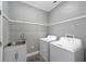 Laundry room with washer, dryer, utility sink, and ample shelving at 10020 Sw 202Nd Cir, Dunnellon, FL 34431
