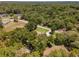 House nestled in a wooded area, accessible by a nearby road. Surrounding landscape includes other homes and open space at 10020 Sw 202Nd Cir, Dunnellon, FL 34431