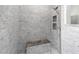 Walk-in shower with grey brick tile and built-in seat at 10020 Sw 202Nd Cir, Dunnellon, FL 34431