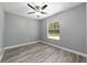 Simple bedroom with grey walls, wood-look floors, and window at 10020 Sw 202Nd Cir, Dunnellon, FL 34431