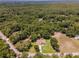 Aerial view of a single Gathering home on a wooded lot, showcasing a large yard at 10020 Sw 202Nd Cir, Dunnellon, FL 34431