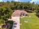 Aerial view of a single Gathering home with a three car garage and lush landscaping at 10020 Sw 202Nd Cir, Dunnellon, FL 34431