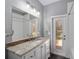 Bathroom with granite vanity, white cabinets and exterior access at 10020 Sw 202Nd Cir, Dunnellon, FL 34431