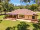 Single-story home with screened porch and brown roof, situated on a grassy lot at 10020 Sw 202Nd Cir, Dunnellon, FL 34431