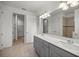 Bathroom with double vanity, gray cabinets, and view of shower at 10145 Sw 89Th Loop, Ocala, FL 34481