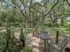 Wooden deck with metal table and chairs, surrounded by lush landscaping at 4344 Cr 542H, Bushnell, FL 33513