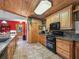 Kitchen with wood cabinets, granite countertops, and black appliances at 4344 Cr 542H, Bushnell, FL 33513