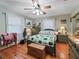 Bedroom with wooden floors, ceiling fan, and green furniture at 4344 Cr 542H, Bushnell, FL 33513