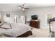 Main bedroom with large bed, TV, and access to the bathroom and outdoor space at 5005 Sw 106Th St, Ocala, FL 34476
