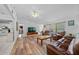 Living room with LVP flooring, leather furniture and view of kitchen at 13027 Ne 7Th Loop, Silver Springs, FL 34488