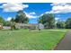 House exterior with a large yard and beautiful landscaping at 13027 Ne 7Th Loop, Silver Springs, FL 34488