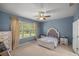 Spacious bedroom with neutral walls, ceiling fan, and large window at 9818 Sw 63Rd Loop, Ocala, FL 34481