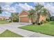 Tan two-story house with three car garage and landscaping at 9818 Sw 63Rd Loop, Ocala, FL 34481