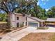 Two-story house with stone fireplace, attached garage, and landscaped yard at 14260 Ne 40Th Ct, Anthony, FL 32617