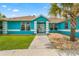 A teal house with a white trim and a walkway leading to the entrance at 3153 Sw Breezy Point Dr, Dunnellon, FL 34431