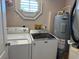Bright laundry room, featuring a washer, dryer, and water heater at 56633 Otter Rd, Astor, FL 32102