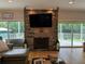 Living room fireplace with stone surround and large TV above at 56633 Otter Rd, Astor, FL 32102