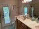 Bathroom with double vanity, large mirror, and access to a private deck at 56633 Otter Rd, Astor, FL 32102