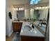 Bathroom with double sinks, wood cabinets, and a corner vanity at 56633 Otter Rd, Astor, FL 32102