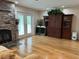 Living room featuring hardwood floors, a stone fireplace, and built-in cabinetry at 56633 Otter Rd, Astor, FL 32102