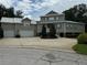 Two-story home with attached garage and circular driveway at 56633 Otter Rd, Astor, FL 32102