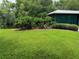 Lush lawn, tropical plants, and a covered patio area at 56633 Otter Rd, Astor, FL 32102