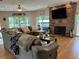 Large living room with a stone fireplace, hardwood floors, and ample natural light at 56633 Otter Rd, Astor, FL 32102