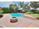 Inviting kidney-shaped pool with fire pit and brick patio at 4818 Se 11Th Pl, Ocala, FL 34471