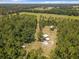 Aerial view showing home, outbuildings, and surrounding trees at 5401 Se 162Nd St # 32, Summerfield, FL 34491