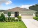 Tan house with a two-car garage and landscaped front yard at 8857 Sw 50Th Ter, Ocala, FL 34476