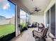 Relaxing screened porch with wicker furniture and ceiling fan, overlooking backyard at 8857 Sw 50Th Ter, Ocala, FL 34476