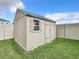 Tan storage shed with single window and double doors in backyard at 8857 Sw 50Th Ter, Ocala, FL 34476