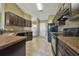 Modern kitchen featuring dark wood cabinets, granite countertops, and stainless steel appliances at 12789 Sw 86Th Cir, Ocala, FL 34473