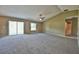 Spacious main bedroom with ceiling fan, carpet, sliding glass doors, and bathroom access at 12789 Sw 86Th Cir, Ocala, FL 34473