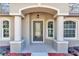 Elegant front entry with arched detail, columns, and glass door at 19610 Sw 93Rd Pl, Dunnellon, FL 34432