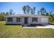 Charming single-story home with a gray exterior and attached garage at 24449 Nw Falcon Ave, Dunnellon, FL 34431