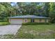 House exterior with attached garage, green metal roof, and landscaping at 7679 S Magnolia Ave, Ocala, FL 34476