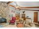 Spacious living room featuring a stone fireplace and exposed wooden beams at 7679 S Magnolia Ave, Ocala, FL 34476