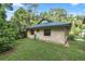 One-story house with stucco siding, green metal roof, and a lush green lawn at 7679 S Magnolia Ave, Ocala, FL 34476