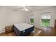 Bright bedroom with wood flooring, dual windows, and a nightstand at 7679 S Magnolia Ave, Ocala, FL 34476