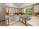 Galley kitchen with white appliances and wood cabinets at 7679 S Magnolia Ave, Ocala, FL 34476