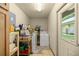 Bright laundry room with washer, dryer and shelving at 7679 S Magnolia Ave, Ocala, FL 34476