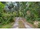 Gravel driveway leading into a wooded area at 7679 S Magnolia Ave, Ocala, FL 34476
