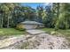 House exterior with attached garage, green metal roof, and landscaping at 7679 S Magnolia Ave, Ocala, FL 34476