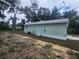 Side view of the house showing its light green exterior and landscaping at 13260 Se 33Rd Ct, Belleview, FL 34420