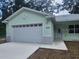 Newly constructed light green house with a two-car garage at 13260 Se 33Rd Ct, Belleview, FL 34420