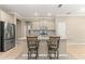 Kitchen features an island with seating, stainless steel appliances, and granite countertops at 9818 Sw 99Th Loop, Ocala, FL 34481