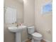 Small bathroom with pedestal sink, toilet and window at 4230 Sw 50Th Cir, Ocala, FL 34474